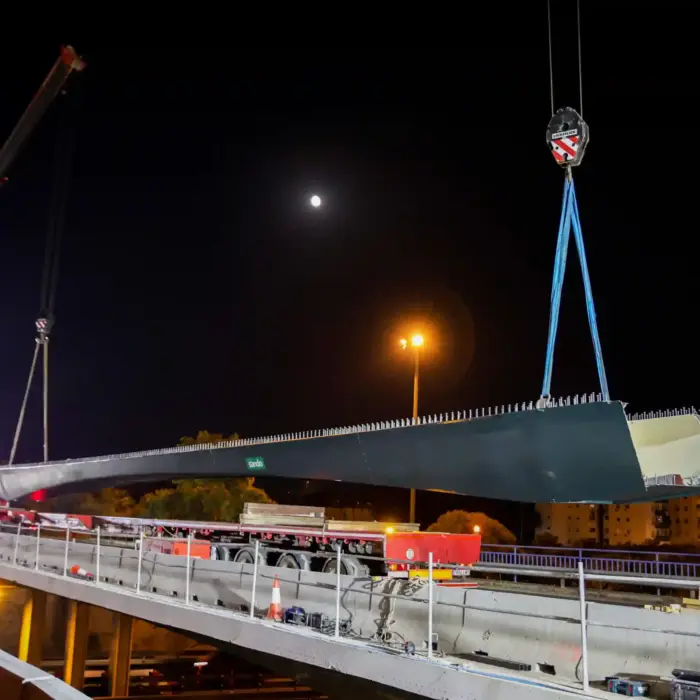 Perspectiva lateral de la estructura del carril BUS-VAO siendo posicionada sobre los pilares.