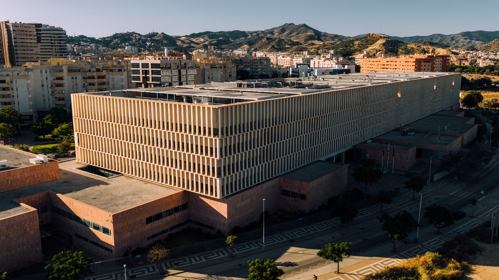 Fotografía aérea actual tomada con dron de un edificio moderno en Málaga al atardecer